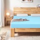 3-inch gel-infused cooling mattress topper in blue resting on a wooden bed frame, enhancing comfort and support for.