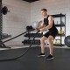 Thick rubber exercise mat set in black, featuring a fitness enthusiast using battle ropes in a gym setting.