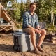 Gray 103 Quart outdoor portable wheeled ice cooler with foldable handles, designed for easy transport and ice retention.