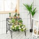Three-tier black metal plant stand with widened grid shelf, ideal for displaying plants indoors or outdoors.