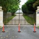 Orange traffic delineator post with reflective collars, durable rubber base, ideal for guiding traffic and parking.