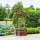 Rustic wooden wishing well planter with adjustable bucket, made from carbonized fir wood, ideal for garden or patio use.