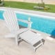 White HDPE Adirondack chair with retractable ottoman, perfect for outdoor relaxation by the poolside.