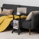 C-shape sofa side table in black with spacious top, mesh shelf, and casters for easy movement in any room setting.