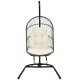 Hanging wicker egg chair with stand in beige, featuring a sturdy steel frame and comfortable cushions for outdoor or.