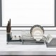 Aluminum expandable dish drying rack with drainboard and swivel spout, organized for cutlery, plates, and glasses.