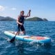 Wide inflatable stand-up paddle board in blue, featuring textured EVA deck and removable fins for stability on the.