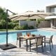 Beige 11 x 9 FT cantilever patio umbrella with 360° rotation, placed by a poolside dining set for outdoor shade.