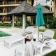 Adjustable white patio sun lounger with wheels, featuring a storage box, perfect for poolside relaxation.