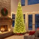 12 ft prelit artificial Christmas tree with 2517 branch tips, glowing LED lights, set in a cozy living room.