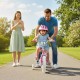 Child riding a pink 12-inch bike with training wheels, featuring adjustable handlebars and a hand brake for safety.