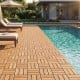 Acacia wood interlocking deck tiles arranged around a pool, showcasing a natural waterproof design for outdoor spaces.