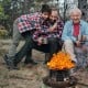 Portable propane fire pit with flames, sturdy black iron design, perfect for camping and outdoor gatherings.