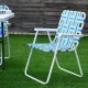 Folding beach chair with blue webbing and white steel frame, ideal for camping and outdoor activities.
