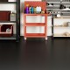 Red tool cart with various cleaning supplies on a textured black garage floor featuring PE mechanic mats.