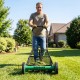 Push reel lawn mower in action, featuring an 18" cutting width and removable grass catcher for efficient lawn care.