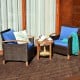 Patio rattan furniture set with blue cushions, featuring acacia wood frame and a coffee table for outdoor relaxation.