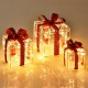 Three lighted gift box decorations with red ribbons and 60 LED lights, perfect for indoor and outdoor Christmas.