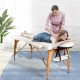 Portable adjustable facial spa bed in white with a therapist and client, ideal for massage and spa treatments.