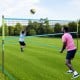 Portable outdoor volleyball net set in green, featuring adjustable poles and robust net, ideal for outdoor games.