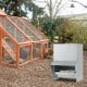 Wall mount galvanized chicken feeder with 50 lbs capacity, designed for easy refilling and reduced food wastage.