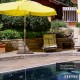 Patio umbrella base stand with adjustable footpads, durable powder-coated steel, ideal for stability on uneven ground.