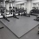 Gray 1/2" puzzle exercise floor mats in a gym setting, providing a non-slip, cushioned surface for workouts.