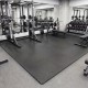 Black 1/2" puzzle exercise floor mats with non-slip texture, ideal for gyms and playrooms, providing impact cushioning.