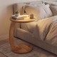 C-shaped side table made of solid teak wood with a thickened top, perfect for bedside or couch use.