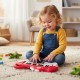 Child playing with a red dinosaur-shaped 25-key kids piano keyboard, featuring lights and music for fun learning.
