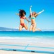 Two women jumping on a 15 feet inflatable gymnastics tumbling mat, perfect for exercise and water activities.