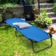 Portable outdoor folding camping bed in blue with sturdy iron frame, ideal for travel and hiking, shown in a garden.