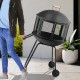 28-inch portable black fire pit on wheels with log grate, ideal for heating or barbecue, shown being moved outdoors.