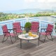 Four red folding beach chairs with a round table, perfect for outdoor gatherings and easy storage.