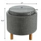 Round gray fabric storage ottoman with removable lid, wooden tray, and non-slip pads, ideal for bedroom use.