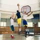 Height adjustable 43-inch basketball hoop with durable steel frame, shown in action during a game indoors.