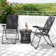 Two gray outdoor folding patio chairs with adjustable backrests and a round black side table on a balcony.