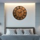 27-inch round wooden wall clock with metal Roman numerals, perfect for living room or bedroom decor.