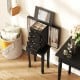 Black jewelry armoire with mirror, featuring 4 drawers and necklace hooks for organized storage in a stylish design.