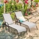 Two adjustable gray outdoor patio lounge chairs with a sturdy steel frame, perfect for poolside relaxation.
