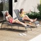 Two women relaxing on dark gray adjustable outdoor lounge chairs, perfect for patio or poolside enjoyment.