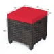 Red cushion-top rattan ottoman with sturdy steel frame, ideal for outdoor use as a seat or footrest.
