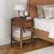 Round end table with drawer and shelf, featuring a sleek wood grain finish and sturdy rubber wood legs for bedroom use.