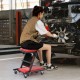 Low profile mechanic creeper in red with padded seat, shown in use for auto repair, featuring 6 wheels for easy.