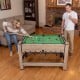 Swivel game table in brown with foosball and pool features, designed for 2-4 players, shown in a living room setting.