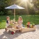 Wooden 2-in-1 sandbox and picnic table with blue umbrella, perfect for outdoor play and snacks for kids aged 3-5.