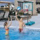 Adjustable 3.8-4.4 ft pool basketball hoop with kids playing in the water, ideal for poolside fun and stability.
