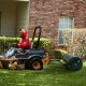 39-inch green lawn roller being towed by a riding mower, made of powder-coated metal for durability and stability.