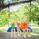 Platform tree swing with four children enjoying, made of blue oxford cloth and metal frame, ideal for outdoor fun.