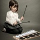 Child playing the 27 Note Glockenspiel Xylophone with rubber mallets, featuring a sturdy wood frame for music learning.
